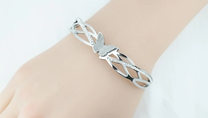 Detailed view of silver butterfly bangle with pave crystals on a woman's wrist