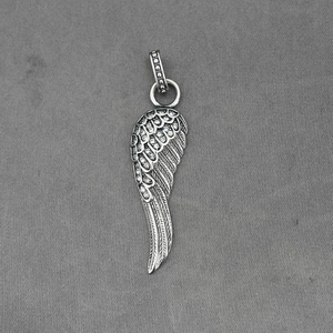Pendentif ailes d'ange en argent vintage avec cristaux sur fond de tissu gris texturé