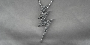 Detail of silver lightning bolt pendant with moon surface texture and box chain