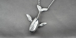Vue macro détaillée du pendentif baleine argenté avec finition en métal martelé
