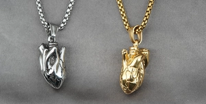 Nahaufnahme anatomischer Herzanhänger in Gold und Silber mit realistischer Muskelstruktur