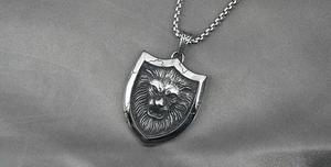 Macro shot of retro silver lion head shield pendant with antique steel box chain texture