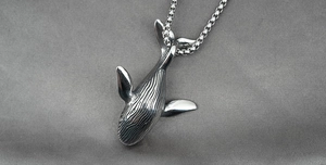 Détail du pendentif baleine argenté avec textures fines et chaîne box en acier inoxydable