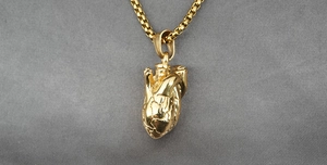 Detaillierte Makroansicht des anatomischen Herzanhängers in Gold mit einer Boxkette