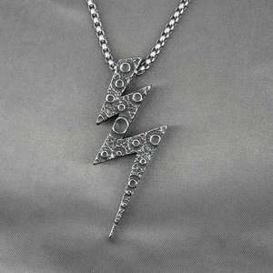 Vintage silver lightning bolt pendant necklace with lunar texture on gray silk background