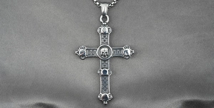Macro detail of gothic skull cross pendant in vintage silver steel with box chain