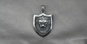 Detailed close-up of a vintage lion head shield pendant in silver-tone titanium steel