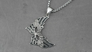 Detailed view of silver wing pendant featuring pave-set black rhinestones on box chain