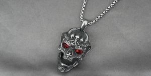 Macro shot of vintage skull pendant with red rhinestone eyes on stainless steel box chain