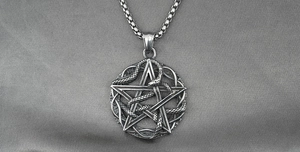 Detailed macro view of vintage star and cobra snake pendant with retro steel box chain
