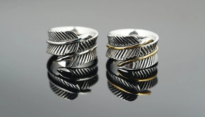 Détails macro de bagues plumes rétro avec finition argent antique et bords dorés