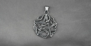 Macro shot of vintage steel pendant featuring a cobra snake coiled around a pentagram star