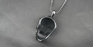 Macro shot of polished stainless steel gothic skull pendant with detailed hollow back