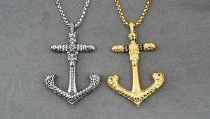 Close-up of gold and silver anchor pendants with skull and cross details on box chains