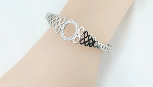 Détail d'un bracelet évidé argenté avec un cercle central serti de cristaux scintillants