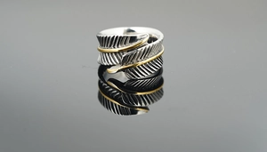 Vue macro de la bague plume rétro avec finition argent or et anneau ouvert réglable