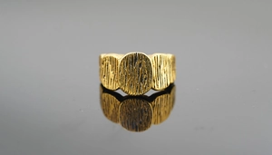 Macro shot of gold wide ring with natural wood bark texture and vintage finish