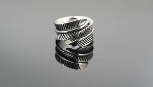 Détail macro montrant la texture plume vintage et l'argent oxydé sur la bague homme