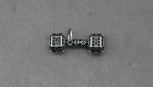 Gros plan du pendentif haltère en argent serti de cristaux noirs pour collier fitness