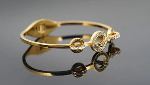 Détail d'un bracelet en acier rose doré avec chiffres romains et cristaux pavés