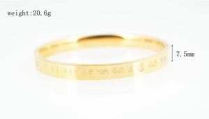 Macro detail of 7.5mm wide gold titanium bangle with engraved religious scripture