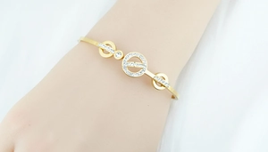 Détail du bracelet jonc doré rose avec trois cercles sertis de micro-oxydes de zirconium