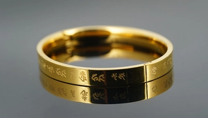 Macro shot of gold stainless steel bangle with engraved religious scripture characters