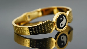 Macro shot of gold Tai Chi Bagua bracelet with engraved Taoist scriptures and patterns