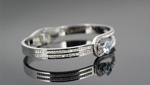 Detail of buckle-style titanium steel bracelet with sapphire blue stone and pave diamonds