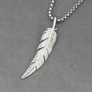 Minimalist silver feather pendant necklace with detailed texture on a box chain