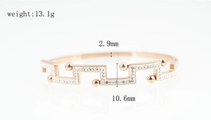 Détail du bracelet en or rose avec motif de grande muraille, zircons blancs et perles de métal