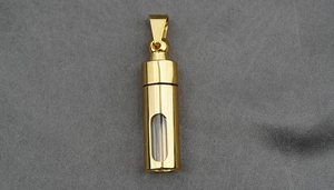 Macro shot of gold stainless steel capsule pendant with clear window and mirror finish