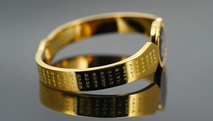 Macro shot of gold-plated titanium steel cuff bracelet with engraved Buddhist scriptures