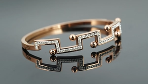 Détail du bracelet or rose avec motifs géométriques et cristaux étincelants