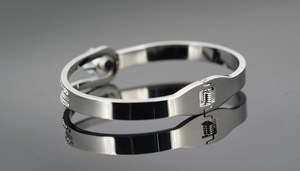 Close-up of titanium steel belt buckle bracelet with diamond setting on mirror surface