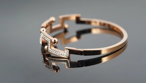 Vue détaillée d'un bracelet géométrique or rose avec motif de mur serti de diamants