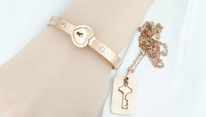 Detail of rose gold couples jewelry set with heart lock bangle and key pendant necklace