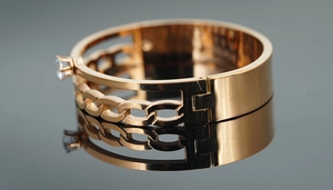 Détail macro du bracelet jonc en titane or rose avec chaîne tissée et zircon serti griffes