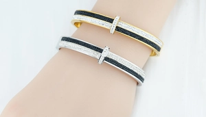 Detail of two-tone titanium steel bangles with sparkling inlaid rhinestones on wrist