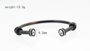 Détail d'un bracelet jonc en acier titane noir orné de cristaux scintillants