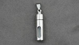 Macro shot of silver stainless steel pendant with glass window for perfume or ashes