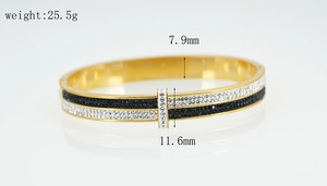 Detail showing 7.9mm wide two-tone black and white crystal pave bangle in gold finish