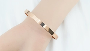 Bracelet minimaliste en acier titane rose doré porté au poignet pour la taille