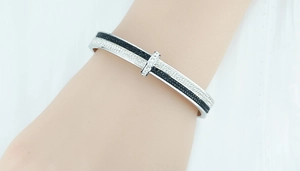 Close-up of a silver titanium steel open bangle with black and white pavé rhinestones