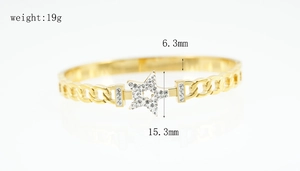 Macro shot of gold star bracelet with white zircon inlay and chunky Cuban chain links