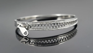 Detailed macro view of silver zipper shaped bracelet with shimmering inlaid rhinestones
