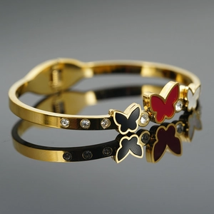 Eleganter goldener Schmetterlingsarmreif mit Emaille-Details und funkelnden Strasssteinen