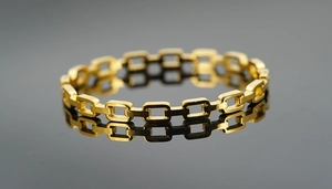 Macro shot of gold woven chain link ring with geometric pattern and mirror reflection