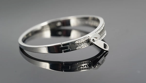 Detail of silver zipper bangle featuring rhinestone edges and Greek meander patterns
