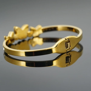 Eleganter goldfarbener Titanstahl-Armreif mit Schmetterling-Charm und Federverschluss